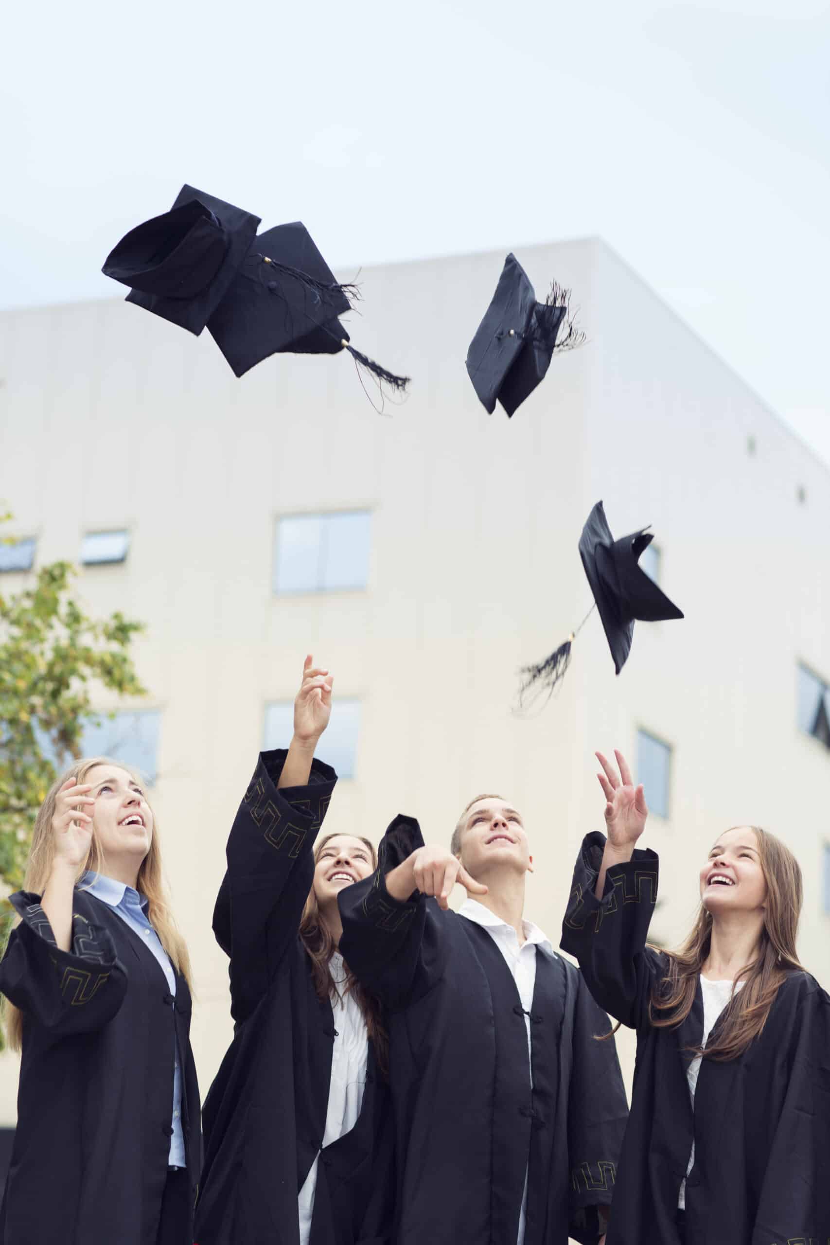 Cheering High School Graduates Throwing Caps Into Air.
